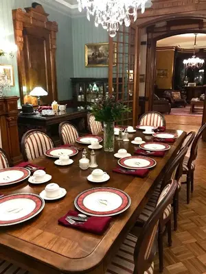a long wooden table with chairs and a dining room at Batcheller Mansion Inn in Saratoga Springs