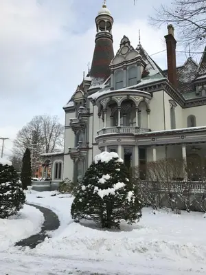 a large house with snow on the ground in front of it at Batcheller Mansion Inn in Saratoga Springs