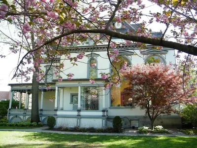 a house with pink blossoms in front of it at Batcheller Mansion Inn in Saratoga Springs