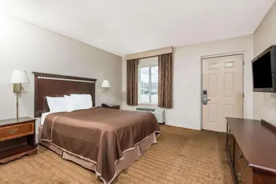 a hotel room with a bed and a flat screen tv at Howard Johnson by Wyndham Springfield in Springfield