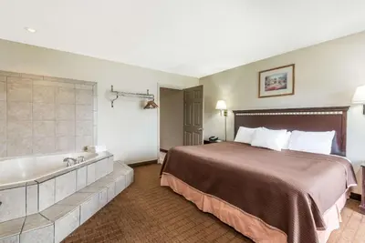 a hotel room with a bed and a bath tub at Howard Johnson by Wyndham Springfield in Springfield