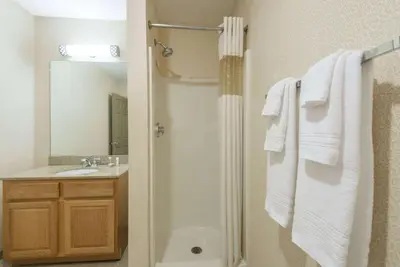 a bathroom with a shower and a sink with towels at Howard Johnson by Wyndham Springfield in Springfield
