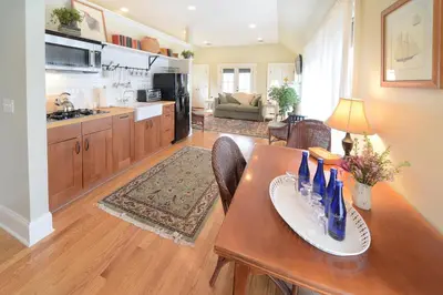 a kitchen and living room with a wooden table and a dining room at The Springwater Bed and Breakfast in Saratoga Springs