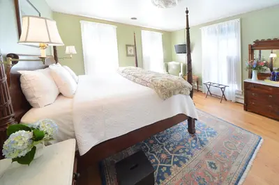 a bedroom with a large bed and a rug at The Springwater Bed and Breakfast in Saratoga Springs