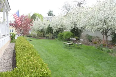 a yard with two picnic tables and an american flag at The Springwater Bed and Breakfast in Saratoga Springs