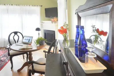 a living room with a table with a laptop and blue vases at The Springwater Bed and Breakfast in Saratoga Springs