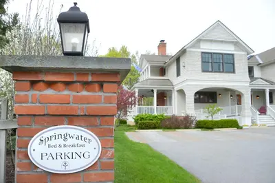 a brick wall with a sign in front of a house at The Springwater Bed and Breakfast in Saratoga Springs