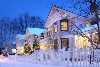 a white fence in front of a house at The Springwater Bed and Breakfast in Saratoga Springs