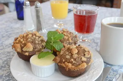 a plate with three muffins on a table with drinks at The Springwater Bed and Breakfast in Saratoga Springs