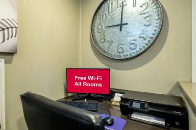 a desk with a computer and a clock on the wall at Red Roof Inn and Suites Herkimer in Herkimer