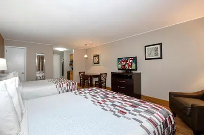 a hotel room with two beds and a flat screen tv at Red Roof Inn and Suites Herkimer in Herkimer