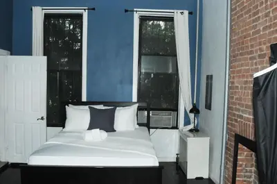 a bed sitting in a room with two windows at Plush Spacious 1 bedroom apt Williamsburg in Brooklyn