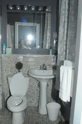 a person taking a picture of a bathroom with a toilet and sink at Plush Spacious 1 bedroom apt Williamsburg in Brooklyn