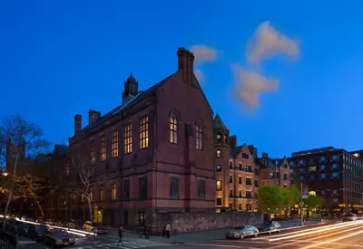 a large brick building on a city street at night at The High Line Hotel in New York