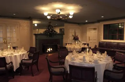 a dining room with tables and chairs and a fireplace at D. Hotel Suites & Spa in Holyoke
