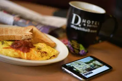 a plate with an egg and toast and a cell phone at D. Hotel Suites & Spa in Holyoke