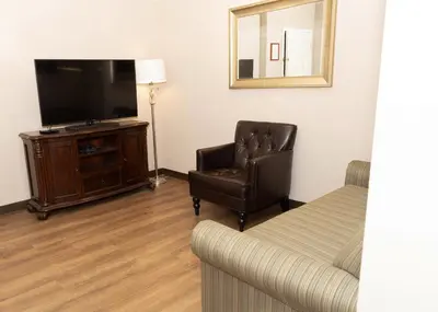 a living room with a couch and a chair and a television at D. Hotel Suites & Spa in Holyoke