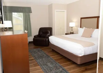 a hotel room with a bed and a chair at D. Hotel Suites & Spa in Holyoke