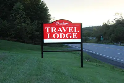 a sign for a travel lodge on the side of a road at Chatham Travel Lodge in Old Chatham