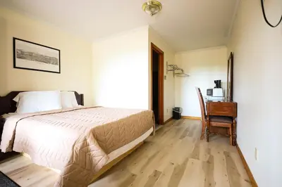 a bedroom with a bed and a desk with a chair at Chatham Travel Lodge in Old Chatham