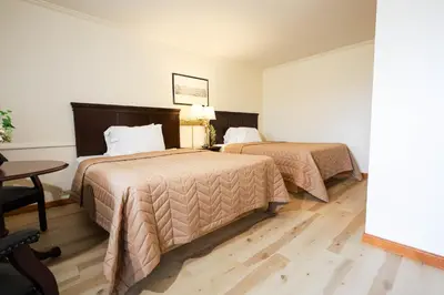 a hotel room with two beds and a table at Chatham Travel Lodge in Old Chatham