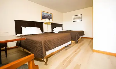 a hotel room with two beds and a desk at Chatham Travel Lodge in Old Chatham