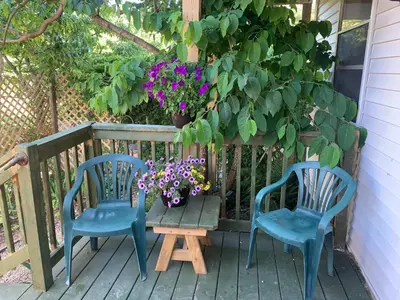 two chairs and a table on a porch with flowers at Micosta Leisure Inn in Hudson