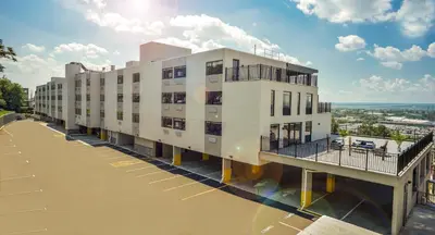 a large white building with balconies on a street at Wyndham Garden North Bergen - Secaucus in North Bergen