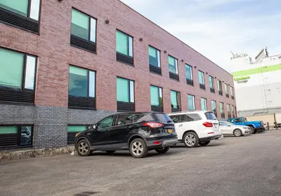 two cars parked in front of a brick building at 7 Days Hotel in Bronx