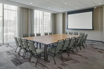 a conference room with a large wooden table and chairs at Courtyard by Marriott Albany Airport in Albany