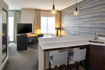 a hotel room with a sink and a desk at Residence Inn by Marriott Albany Airport in Albany