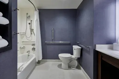 a bathroom with a toilet and a tub and a sink at Residence Inn by Marriott Albany Airport in Albany