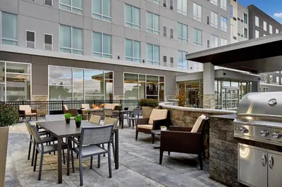 a patio with a grill and tables and chairs at Residence Inn by Marriott Albany Airport in Albany