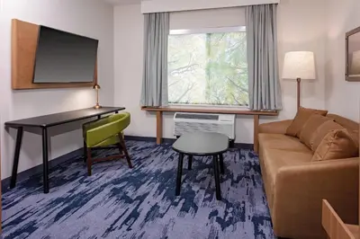 a living room with a couch and a desk at Fairfield Inn & Suites by Marriott Queensbury Glens Falls/Lake George in Queensbury