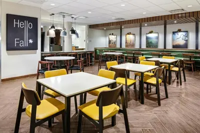 a restaurant with tables and yellow chairs at Fairfield Inn & Suites by Marriott Queensbury Glens Falls/Lake George in Queensbury