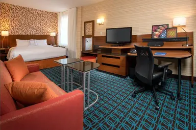 a hotel room with a bed and a desk with a television at Fairfield Inn & Suites New York Manhattan/Downtown East in New York