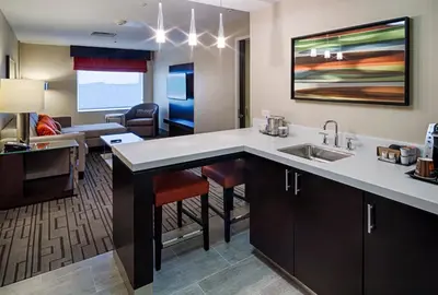 a kitchen with a sink and a living room at DoubleTree by Hilton Hotel Bristol in Bristol