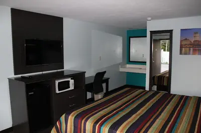 a hotel room with a bed and a flat screen tv at Castle Inn East Greenbush Castleton-on-hudson in East Greenbush