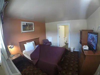 a hotel room with a bed and a television at Castle Inn East Greenbush Castleton-on-hudson in East Greenbush