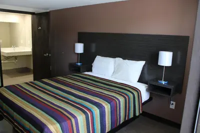 a bedroom with a bed with a striped blanket and two lamps at Castle Inn East Greenbush Castleton-on-hudson in East Greenbush