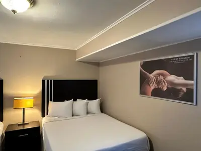 a hotel room with a bed and a picture of a woman at Community Court Motel in Saratoga Springs