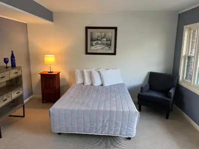 a bedroom with a bed and a chair at Community Court Motel in Saratoga Springs