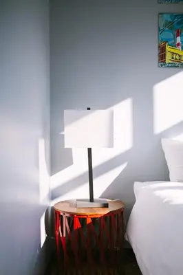 a lamp on a table next to a bed at The Local NY Hostel in Queens