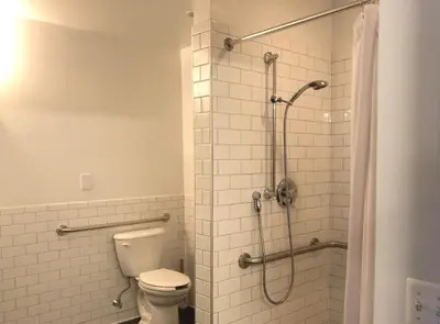a bathroom with a toilet and a shower at The Local NY Hostel in Queens