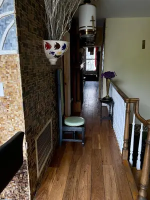 a hallway with a chair and a brick wall at NYC Townhouse Apartment in New York