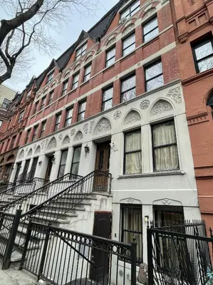 a large brick building with stairs in front of it at NYC Townhouse Apartment in New York