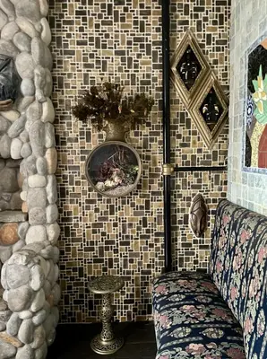 a room with a tiled wall with a couch and a vase at NYC Townhouse Apartment in New York