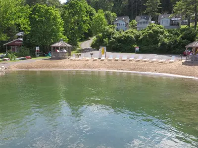 a beach with a gazebo next to a body of water at Bayside Inn & Marina in Cooperstown