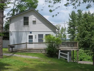 a house with a porch and a deck at Bayside Inn & Marina in Cooperstown