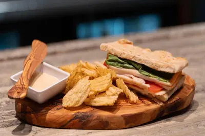 a sandwich and french fries on a wooden cutting board at Best Western Premier Herald Square in New York